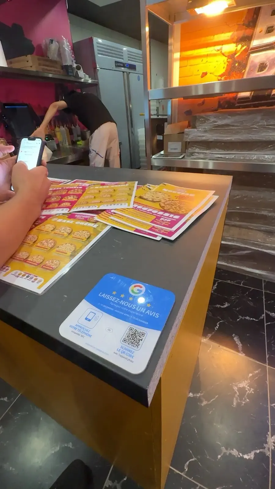 Plaque posée sur le comptoir d'une pizzeria
